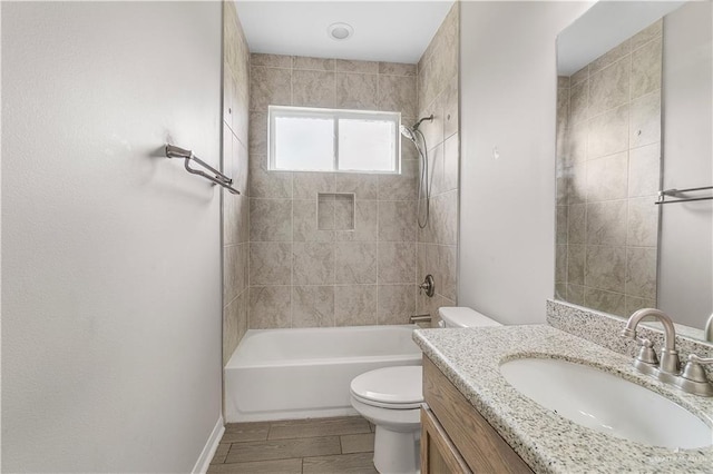 full bathroom featuring tiled shower / bath combo, toilet, and vanity