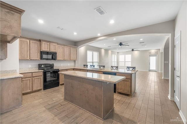 kitchen featuring ceiling fan, sink, light hardwood / wood-style flooring, kitchen peninsula, and black appliances