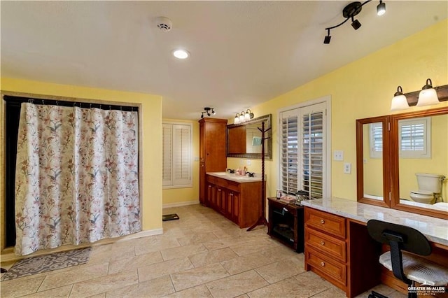 full bath featuring vanity and baseboards