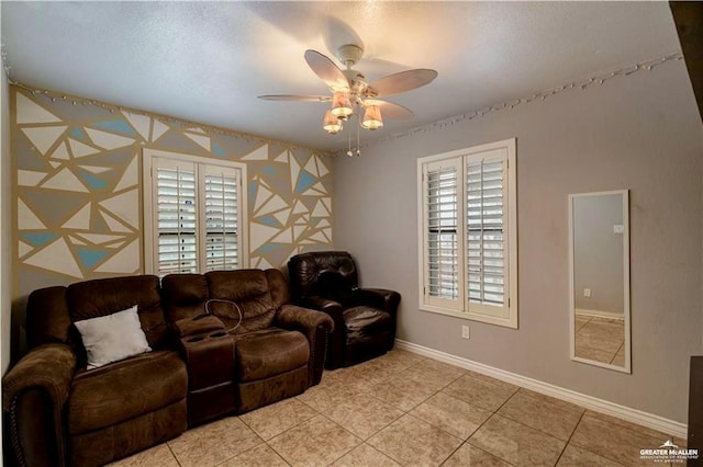 living room with a wealth of natural light, light tile patterned floors, baseboards, and a ceiling fan