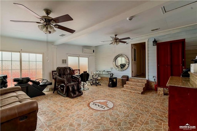 living area with stone finish floor, beamed ceiling, visible vents, and ceiling fan