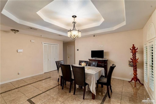 dining room with visible vents, baseboards, a tray ceiling, light tile patterned floors, and an inviting chandelier