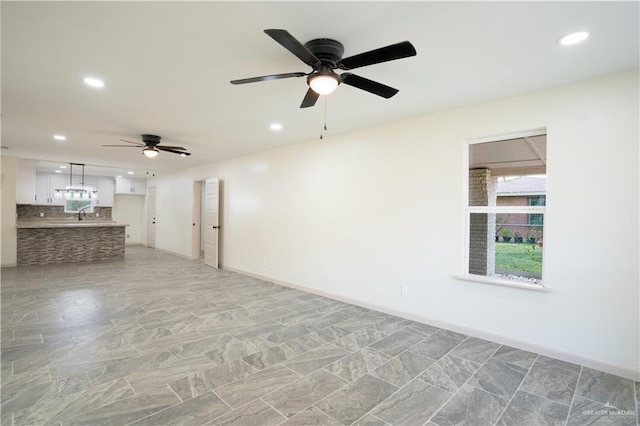 unfurnished room featuring ceiling fan and sink