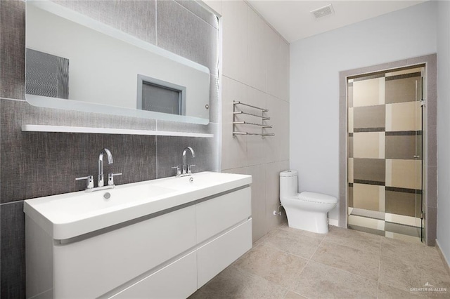 full bath featuring toilet, a sink, visible vents, and tile walls