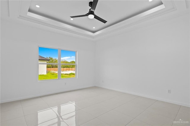 unfurnished room featuring baseboards, a raised ceiling, and ceiling fan