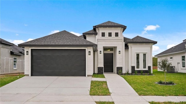 view of front of house with a front yard, concrete driveway, a garage, and roof with shingles