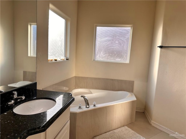 bathroom with tile patterned flooring, vanity, and a bath