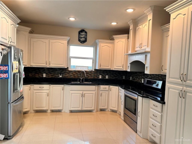 kitchen featuring tasteful backsplash, stainless steel appliances, sink, light tile patterned floors, and dark stone countertops