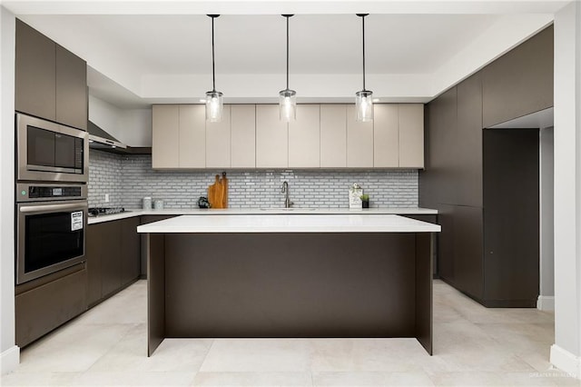 kitchen with modern cabinets, a kitchen island, stainless steel appliances, light countertops, and a sink