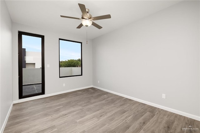 unfurnished room featuring ceiling fan, baseboards, and wood finished floors