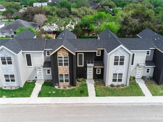 5318 N Crown Pt, Pharr, TX 78577 - view of front facade featuring stone siding, stucco siding, a front yard, and a shingled roof