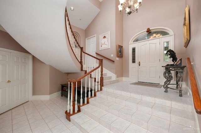 entrance foyer with light tile patterned flooring, high vaulted ceiling, and an inviting chandelier