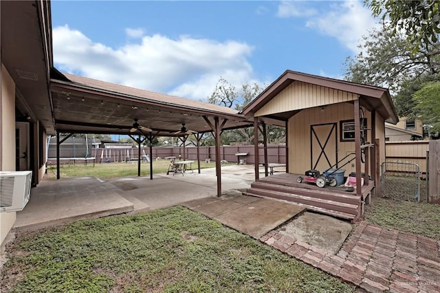 exterior space with a storage unit, ceiling fan, and ac unit