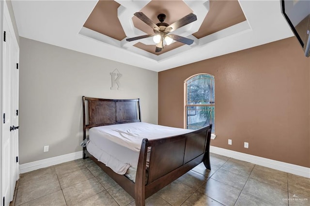 bedroom featuring a raised ceiling, ceiling fan, and tile patterned floors