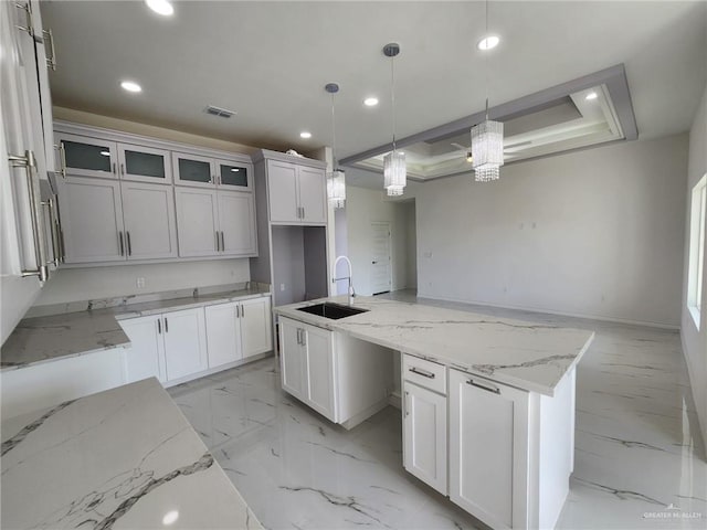 kitchen featuring white cabinetry, sink, and hanging light fixtures