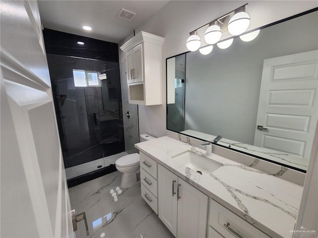 bathroom featuring vanity, a shower with shower door, and toilet