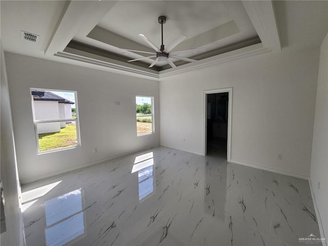 spare room featuring a raised ceiling and ceiling fan