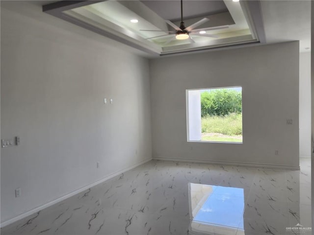 unfurnished room featuring a tray ceiling and ceiling fan