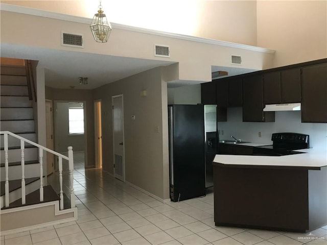 kitchen featuring pendant lighting, refrigerator with ice dispenser, sink, electric range, and a high ceiling