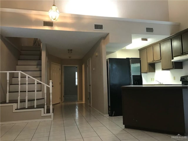 kitchen with black refrigerator with ice dispenser and light tile patterned floors