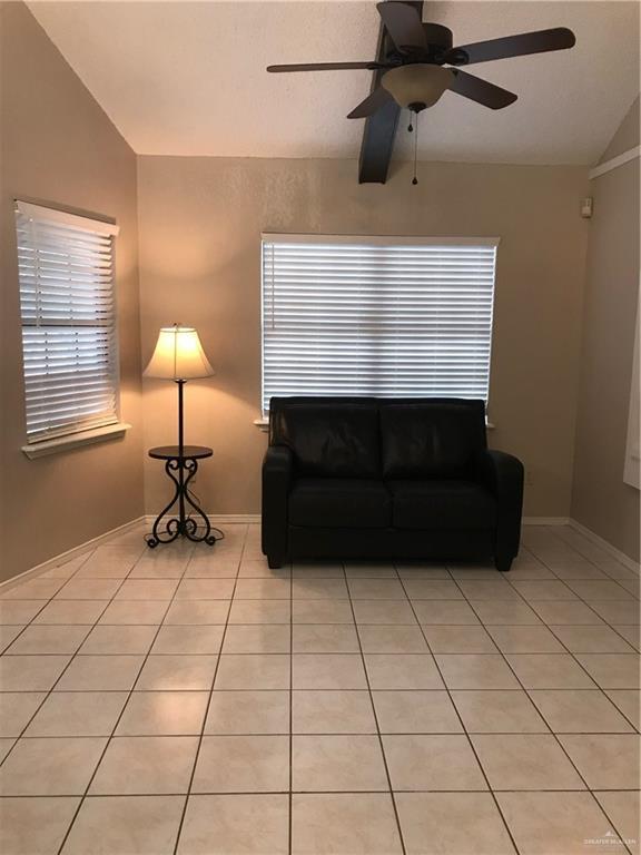 tiled living room with vaulted ceiling and ceiling fan