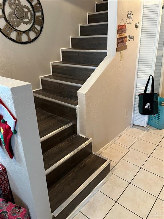 staircase featuring tile patterned flooring