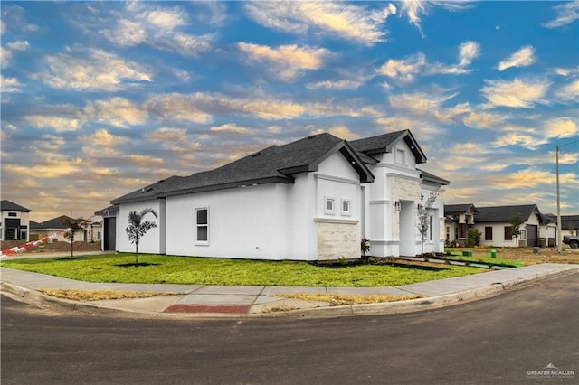 property exterior at dusk featuring a lawn