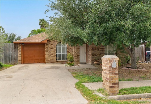 6402 S Mars Ln, Pharr, TX 78577 - view of property hidden behind natural elements with an attached garage, brick siding, driveway, and fence