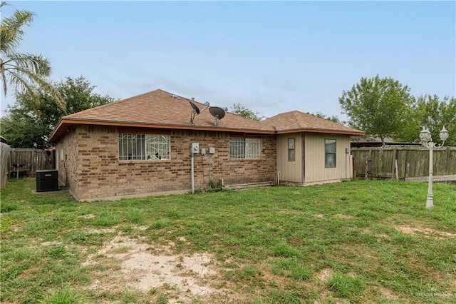 6402 S Mars Ln, Pharr, TX 78577 - rear view of property featuring a yard, brick siding, central AC unit, roof with shingles, and a fenced backyard