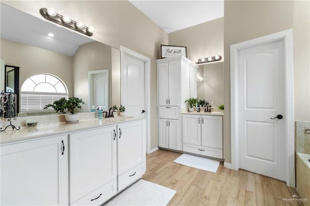 2003 N 44th Ln, Mcallen, TX 78501 - bathroom featuring vanity, wood finished floors, a bathtub, and vaulted ceiling