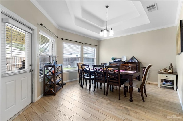 2003 N 44th Ln, Mcallen, TX 78501 - dining area featuring a chandelier, a tray ceiling, baseboards, light wood-style flooring, and crown molding