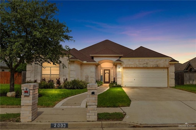 2003 N 44th Ln, Mcallen, TX 78501 - view of front of property with brick siding, an attached garage, concrete driveway, and roof with shingles