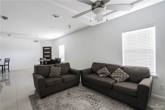 living room featuring baseboards, visible vents, a ceiling fan, and tile patterned floors