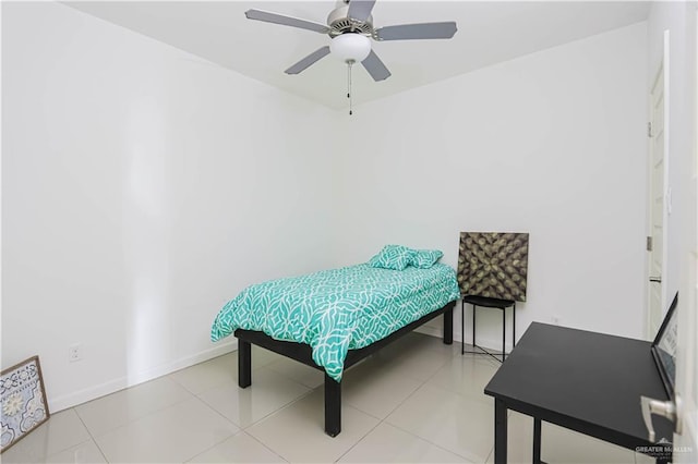 tiled bedroom featuring a ceiling fan and baseboards