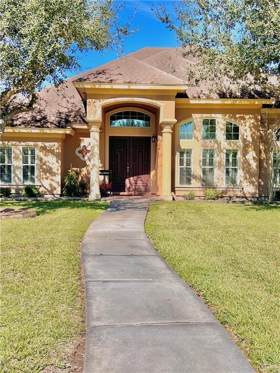 entrance to property featuring a lawn