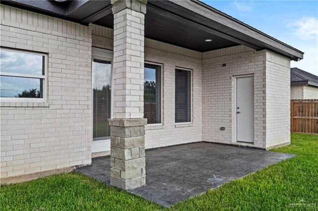 3108 Travis St, Weslaco, TX 78599 - view of exterior entry with a patio area and brick siding