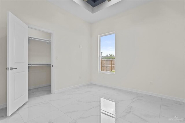 3108 Travis St, Weslaco, TX 78599 - unfurnished bedroom with light marble finish flooring, a spacious closet, and a closet