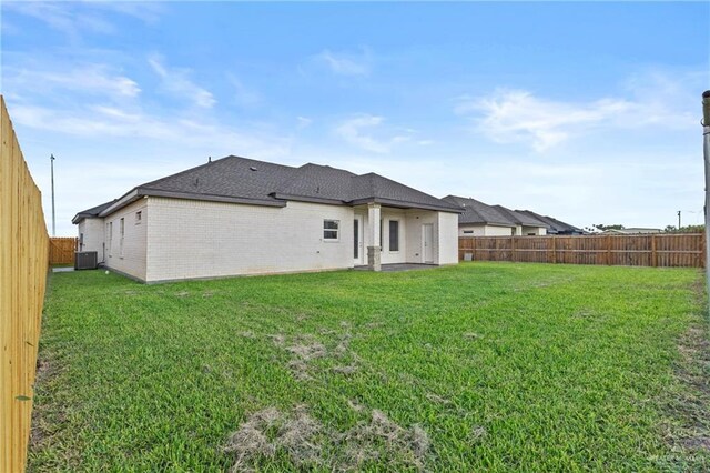 3108 Travis St, Weslaco, TX 78599 - rear view of house featuring a fenced backyard, brick siding, and roof with shingles