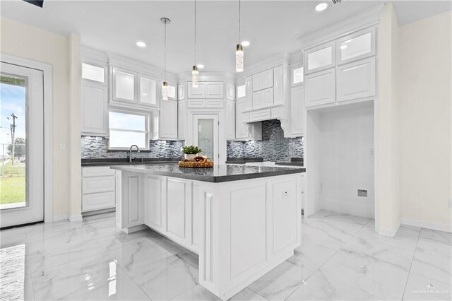 3108 Travis St, Weslaco, TX 78599 - kitchen with light marble finish flooring, white cabinets, dark countertops, recessed lighting, and decorative backsplash
