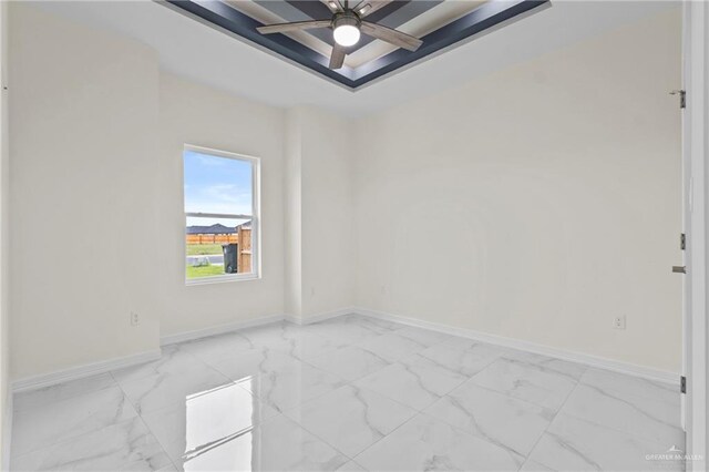 3108 Travis St, Weslaco, TX 78599 - empty room with a tray ceiling, light marble finish flooring, and ceiling fan