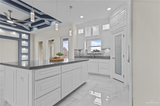 3108 Travis St, Weslaco, TX 78599 - kitchen with dark countertops, recessed lighting, a center island, light marble finish floors, and glass insert cabinets