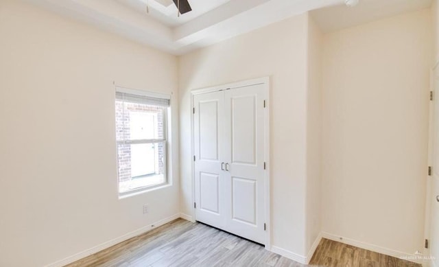 unfurnished bedroom with ceiling fan, a closet, and light hardwood / wood-style floors