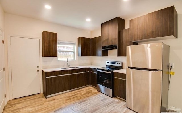 kitchen featuring light wood-type flooring, stainless steel appliances, dark brown cabinetry, and sink