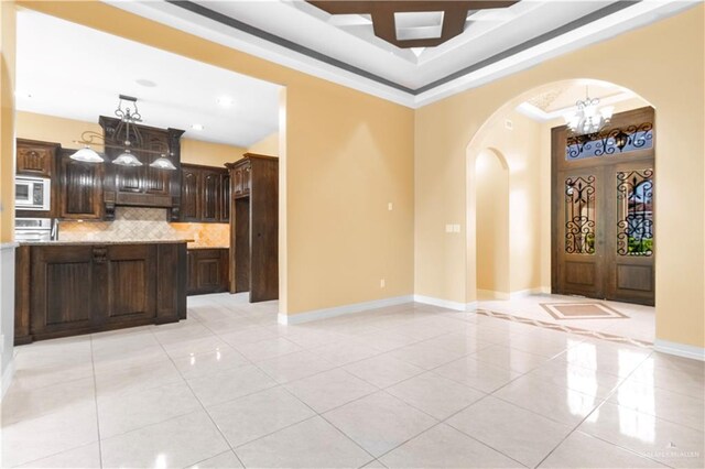 3210 Salvador Ave, Edinburg, TX 78539 - interior space featuring light tile patterned floors, a notable chandelier, crown molding, baseboards, and arched walkways