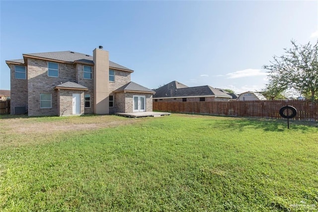 back of house with a lawn and a wooden deck