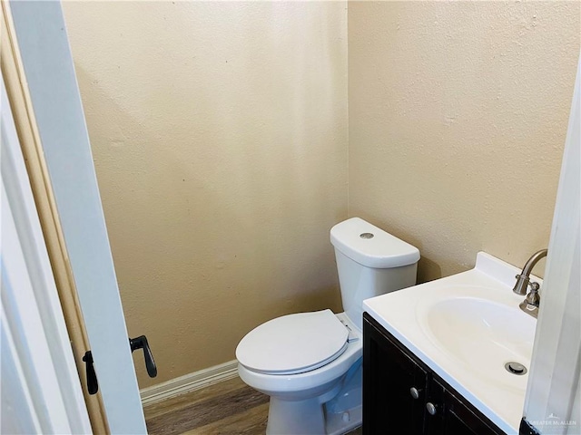 bathroom featuring toilet, wood-type flooring, and vanity