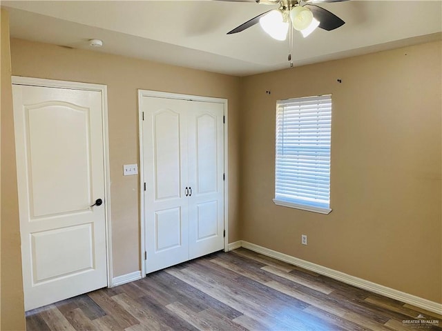 unfurnished bedroom with ceiling fan, wood-type flooring, and a closet