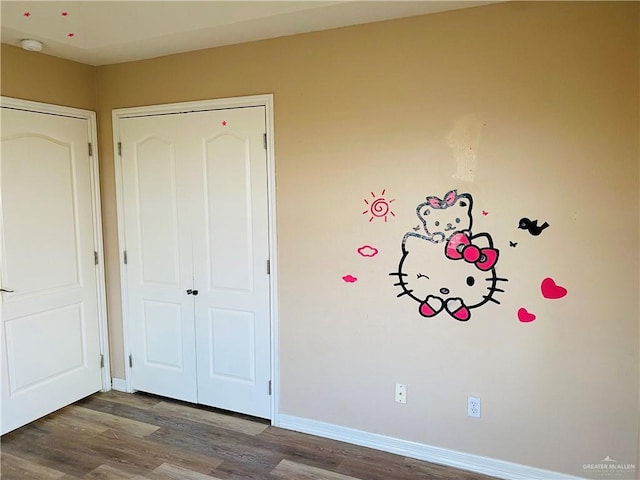 unfurnished bedroom featuring wood-type flooring and a closet