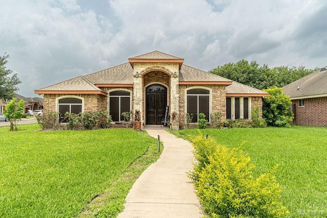 3831 Spicewood Dr, Edinburg, TX 78542 - view of front of home featuring a front yard, roof with shingles, and brick siding