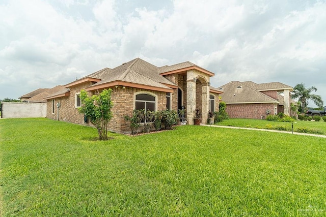 3831 Spicewood Dr, Edinburg, TX 78542 - view of front of house featuring a front lawn, brick siding, stone siding, and roof with shingles